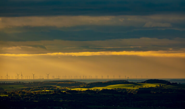 Dramatic winter skies over Belmont sweeping in from the coast.  The wind farm near Blackpool are clearly visible on a very changeable day. The sun bursting through the fast moving clouds spotlights features in the landscape.