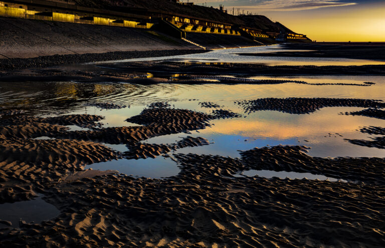 Abstract shapes and textures created by the low sun and receding tide.  Looking like another planet the swiftly receding tide has created some very striking colours and shapes.