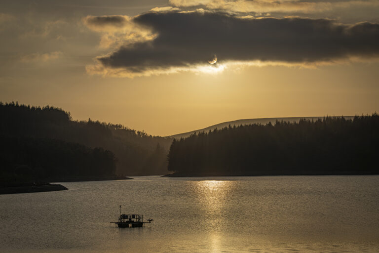 Entwistle Reservoir on a hazy evening in spring.  One of my favourite places to photograph. A sharp bright sunset brings out some hidden silhouettes and almost sepia tones.