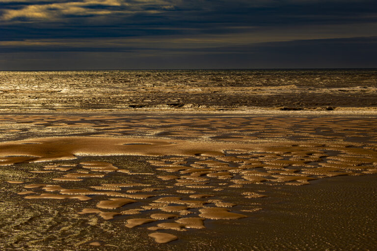 Blackpool Beach on a very windy and moody day.  The tide is going out revealing some stunning shapes and textures.  Stormy clouds and bright patchy sun has created some “different” pictures of an all too familiar place.