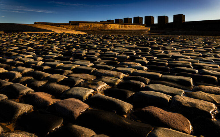 Very early after dawn when the light is nearly red.  The very low sunlight picks out details and shapes in the sand and rocks.